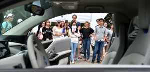Students look at a BMW-i electric car during the kickoff of a social innovation practicum which will look at urban mobility.